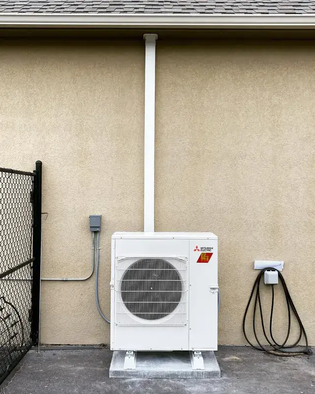 Mitsubishi outdoor unit beside a gate