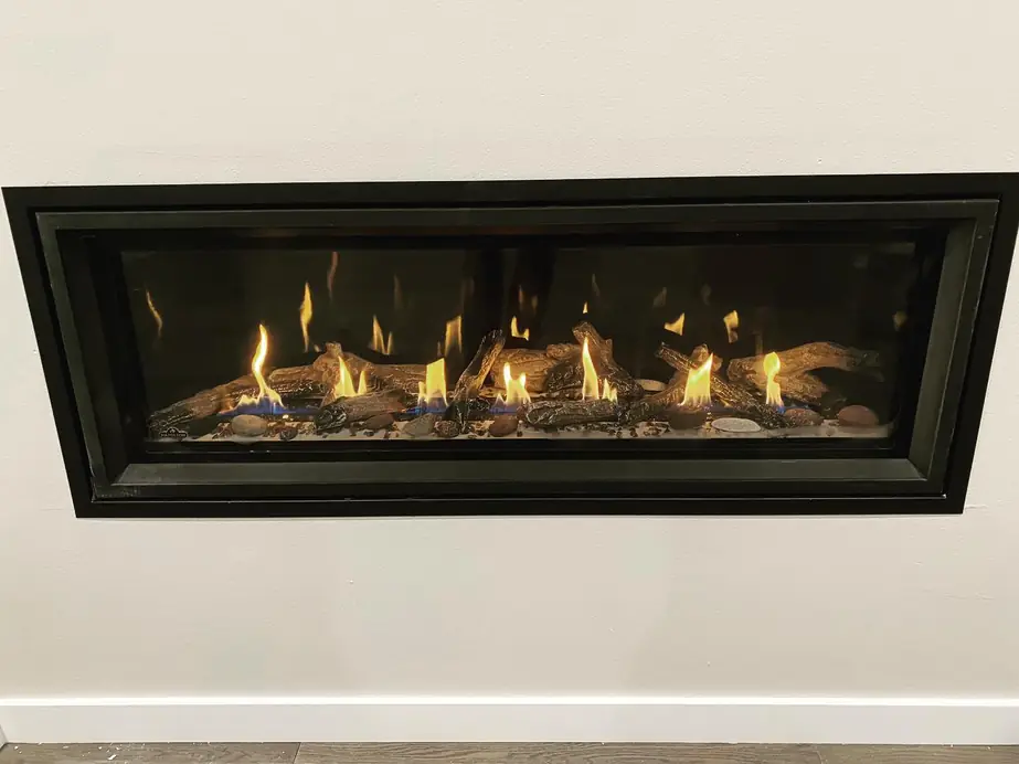 Long linear gas fireplace on a white wall