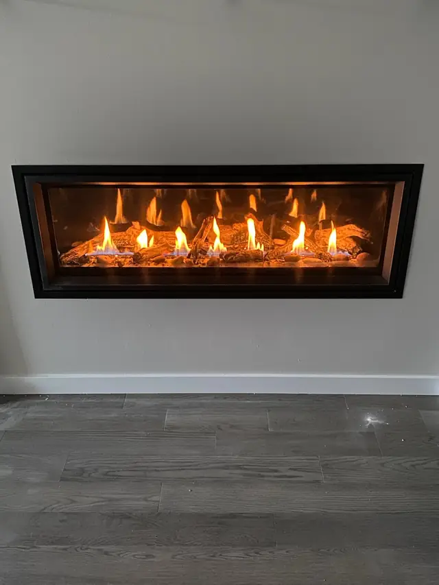 Linear gas fireplace above a wood floor